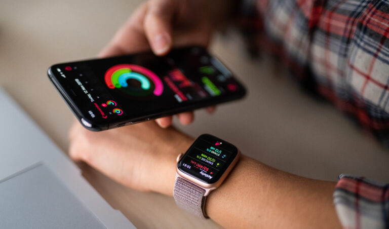 Wearable device showing an Apple Watch and iPhone sync.
