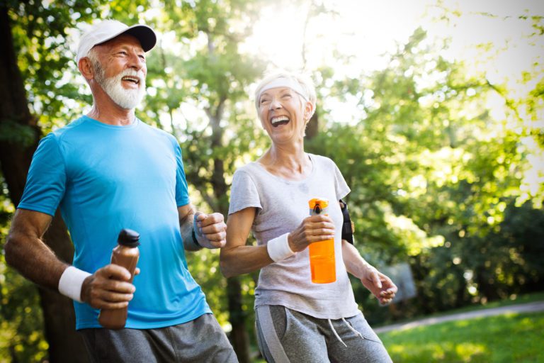 Active senior couple running in the park for healthy life
